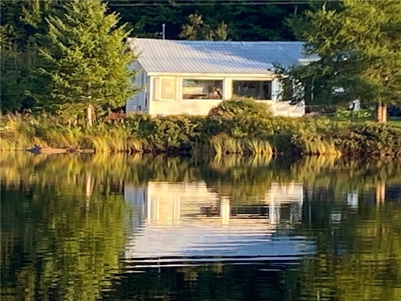 Petit chalet au bord d'un lac naturel tranquille ensemencé de truites